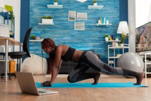 black fit athletic woman training muscle strenght doing mountain climbers position yoga mat dressed sportwear leggings home living room following online instructions 482257 2242